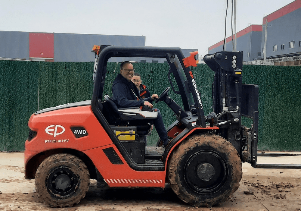 Roter Geländestapler von EP mit zwei Personen auf sandigem Boden bei Prote Adventure